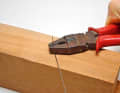 Hold the wire with the grooves of a pair of combination pliers and bend sharp kinks or angles over the edges of a hardwood block