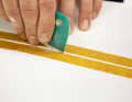 Sand the edges of the scratch at an angle with 120-grit paper. The adhesive tape protects the surrounding area from scratches