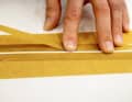 Rimuovere la polvere di carteggiatura e fissare nuovamente il nastro adesivo. Raddoppiare il nastro adesivo in modo che lo stucco sporga un po' più avanti.