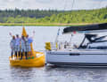 The "Lightworks" crew led by Michael Höfgen celebrates crossing the finish line at the MidsummerSail on the legendary yellow Töre buoy.