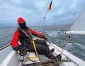 Bien emmitouflée contre le vent froid, Julia Harder pilote le J/22 pendant cette courte journée d'hiver.