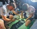 Modalità di riparazione: Robert Stanjek e Sébastien Simon preparano una toppa adesiva per una vela