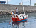 In the harbour of La Réunion, Quenet moves his boat with the wriggriemen, the small ship has no engine