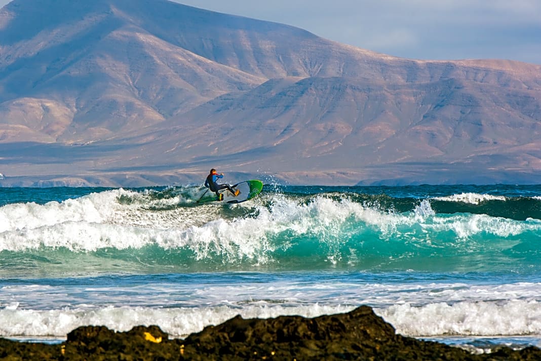 Zum Greifen nah: Wer am Rocky Point Fuerteventuras Wellen schlitzt, hat die Vulkanlandschaft Lanzarotes immer im Rücken.