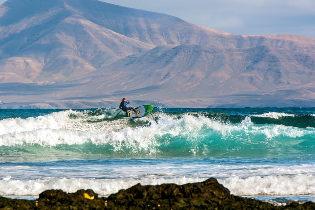 Zum Greifen nah: Wer am Rocky Point Fuerteventuras Wellen schlitzt, hat die Vulkanlandschaft Lanzarotes immer im Rücken.