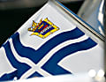 Finnische Yachtclubs führen eine eigene Flagge: Ein schmales weißes Kreuz auf  dem blauen unterscheidet sie von der gewöhnlichen National- und Handels­flagge, das zusätzlich eingefügte  Emblem auch untereinander