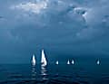 Strahlend weiß leuchten die Segel der Yachten vor einer dunkelgrauen Wolken­wand auf. Was kommt da auf sie zu?