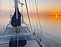 Morgen-Magie: Über Föhr geht die Sonne auf, während das Boot am Anker vor Amrum liegt. Die Insel und Sände bieten hier Schutz