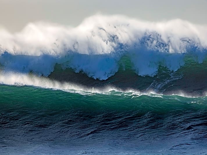 Suchbild mit Surfer – das winzige Masttopp zwischen den beiden Wellen lässt erahnen, dass die Lage ernst ist.
