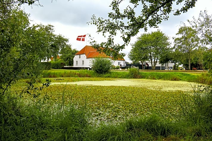 Weiß getünchtes Bauernhaus im beschaulichen Inseldorf. Birkholm ist beinahe so flach wie das angrenzende Wasser der Dänischen Südsee 