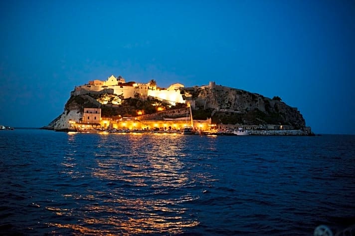   San Nicola am Abend. Hafen und der auf dem Felsen thronende Ort sind in gelbes Licht getaucht