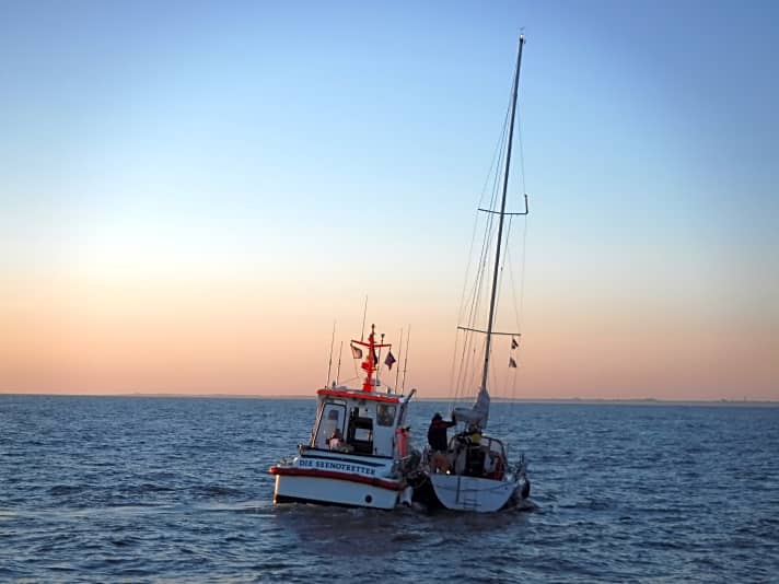   Die nach Grundberührung leckgeschlagene Yacht im Seegatt Accumer Ee wird von einem Boot der Seenotretter in Schlepp genommen