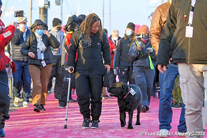   Alexia Barrier verlässt das Dock mit Rückenschmerzen an einer Krücke und in Begleitung ihres Hundes Nikka