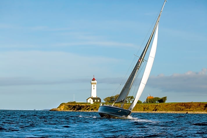 Der markante Leuchtturm Helnæs Fyr am nordwestlichen Eingang der Bucht | ht