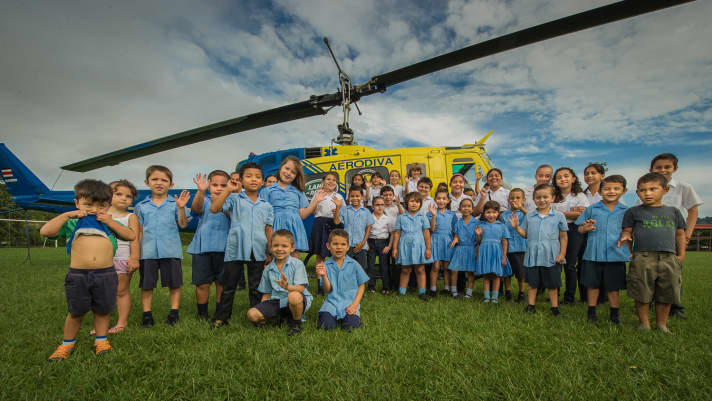   Die Kinder des La Ruta vor dem obligatorischen Helikopter. Laut Veranstalter sind sie vom Rennen begeistert.