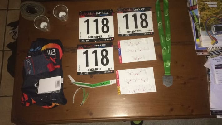   Startnummern, Finisher-Medaille und Höhenprofile.