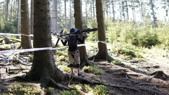   Um einzelne Sektionen mehrmals zu trainieren, schieben oder tragen die Starter ihrer Bikes immer wieder den Berg hoch. 