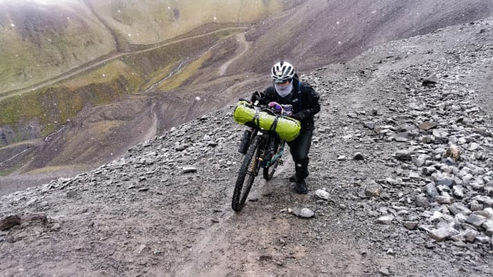   Gianluca Scafuro ist normalerweise das Wetter in der Toskana gewohnt. Am Kegety-Pass hat er alles an, was er an warmen Sachen dabei hat. Minus zwei Grad Celsius und nasse Klamotten fühlen sich in der folgenden Abfahrt dann wenig nach Komfortzone an.