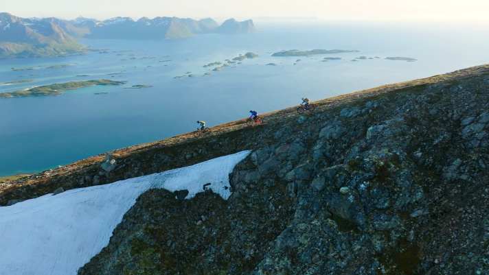 Sea below, snow above: biking in summer in Norway.