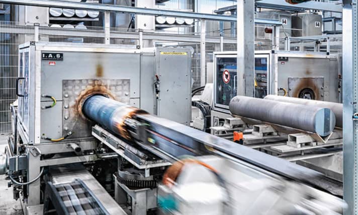   Alu-Felgen: Ein großer Teil des Herstellungsprozesses ist automatisiert. Am Anfang wird aus der erhitzten, plastischen Alu-Legierung ein Endlosprofil in großen Extrudern gepresst.