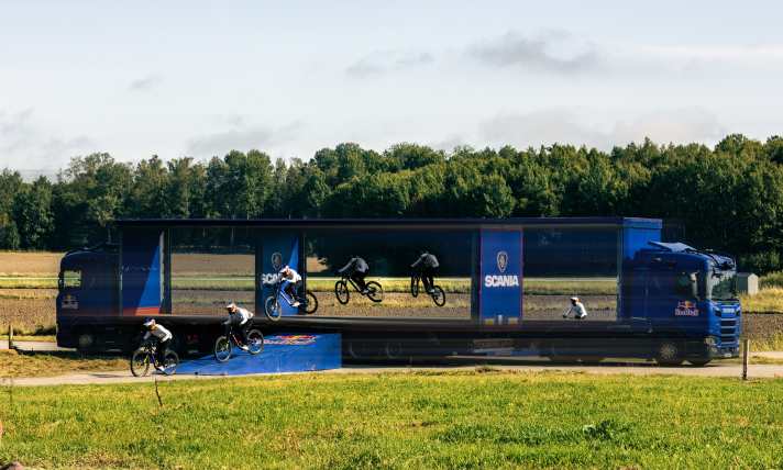 A photo doesn't do the stunt justice, because everything is in motion: The two lorries speeding past each other and Matt Jones flying through the tiny gap.