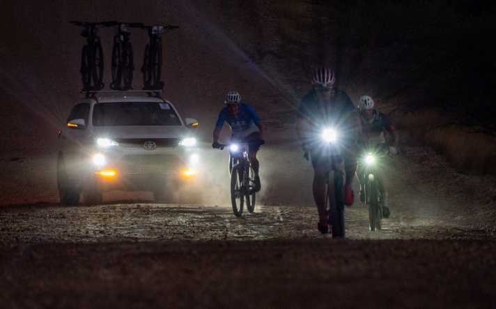The team cars briefly switch on the lights when overtaking, but then leave a large cloud of dust in their wake.