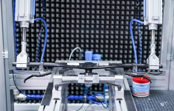   The laboratory area is strictly shielded. There are no windows. Visitors must hand in their mobile phones before entering. Testing expertise is the institute's greatest asset. Zedler fears nothing more than intellectual theft. Here, a Syncros handlebar is undergoing the simulation of a tough off-road ride. Pedalling uphill, downhill and an overload every 4000 load changes, which corresponds to a fall or an unsuccessful riding manoeuvre. Incidentally, the waste heat from the pneumatics is used to heat the building.