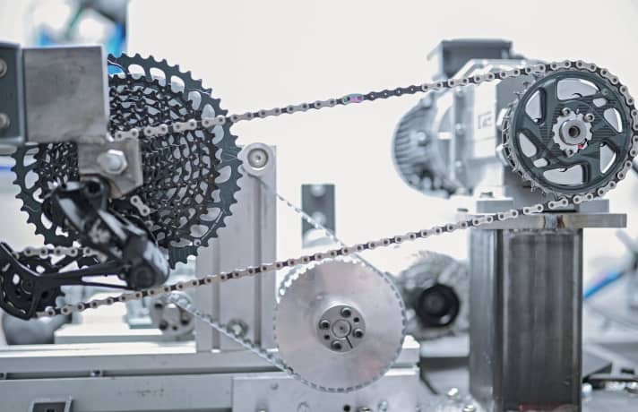   For the comparative wear tests of the 1x12 MTB drivetrains, we used the power of two machines in the BIKE lab. This allows us to put the drivetrains through their paces in fast motion.