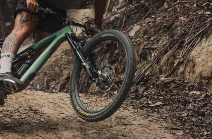 The front wheel is slightly in the air, the body position far forward.