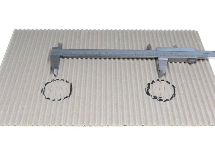 The distance between the sit bones can be determined quickly and easily at home. Simply place a piece of corrugated cardboard on a hard, flat chair or stool, sit on it with a straight back, pull yourself towards the chair with your arms and then measure the distance between the sit bone impressions.