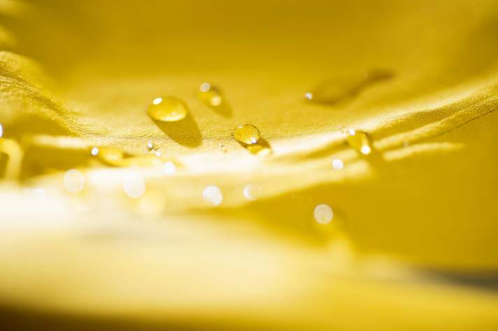 As long as water beads up on the outer layer of the rain jacket, everything is ok. If the material becomes saturated, it needs to be waterproofed again.