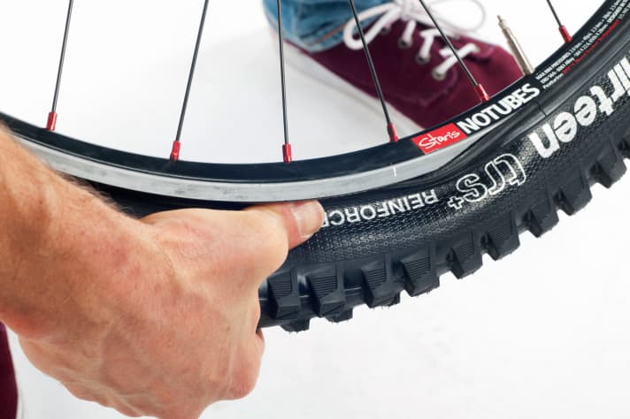 If you press the tyre deep into the rim well and always keep it under tension when preparing the valve, the last piece will pop into the rim easily and without a tyre lever.