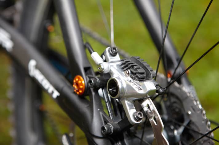   Die XTR Trail besitzt den baugleichen Bremssattel wie die XTR XC, allerdings stecken die Ice-Tech-Bremsbeläge mit Alu-Kühlungsfinne drin. Die kann man aber auch in die XTR XC einbauen – falls man mal in die Alpen startet. Speziell für die All-Mountain-Kategorie gibt es eine Zweifach- Kurbel (FC-M980) mit 38/26 Zähnen, das erhöht die Bodenfreiheit etwas.