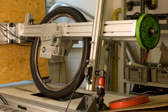   Each of the eight tyres was tested on our in-house drum test bench. To do this, the tyres were run on a Shimano XT wheel at 2.0 bar over a specially prepared drum with different friction values. The tyres were mounted at an angle on the test stand to wear the tread faster and more precisely.