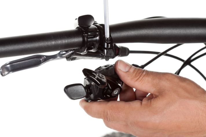   Zuerst schraubt man den Schalthebel von der Lenkerschelle. Danach entfernen Sie die Schelle vom Lenker.