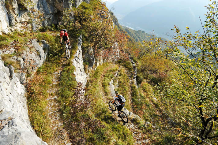   Über den Monte Grappa zieht sich ein wahres Kunstwerk von Wegenetz. Fast schon wie eine Murmelbahn rollt man auf dem Sentiero 153 eine steile Felswand hinunter. Auf den ersten Blick völlig unfahrbar, doch dann ein echtes Pfadwunder für geübte Spitzkehrenfahrer. Von dem alten Frontsteig blickt man dazu bis weit über die Po-Ebene. 