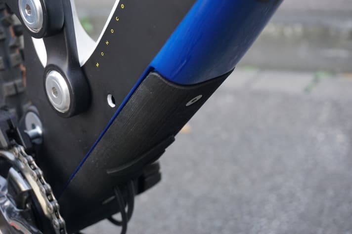   Das wuchtige Carbon Unterrohr wird durch ein Plastik-Schild vor Steinschlägen geschützt. Durch das Loch im Unterrohr kann eine Leitung für Sideswing Umwerfer gelegt werden. Das günstigere Wild Creed Model hat eine Zweifach Kurbel verbaut.