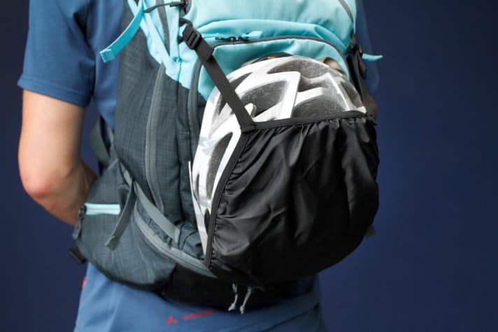 The helmet holder encloses the helmet well, but covers the tool compartment. If you don't need it, it disappears into a Velcro pocket on the outside.