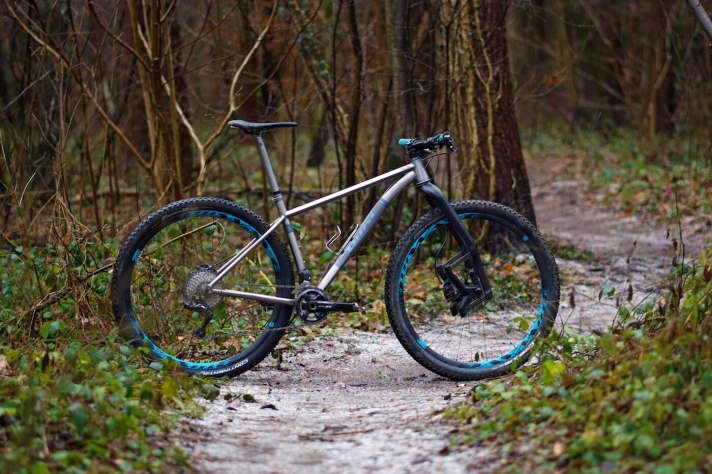   Blaue Anbauteile runden den Titanrahmen mit blauem Schriftzug ab.