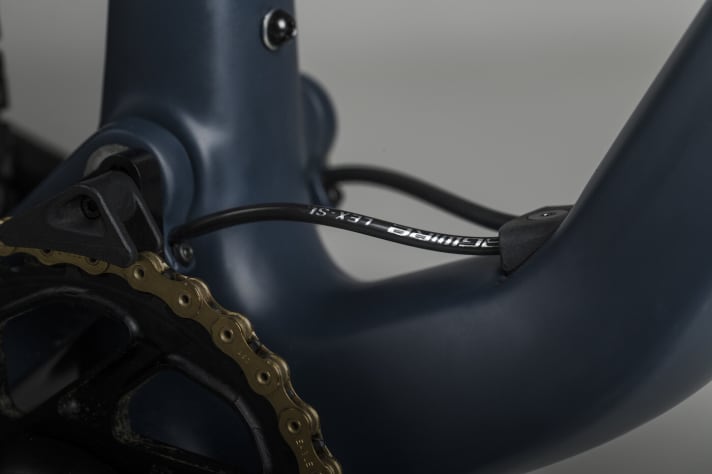   At the lower end of the down tube, the cables emerge briefly from the frame before disappearing again inside the chainstays.