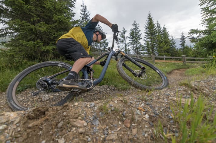   We have already ridden the top version of the Define 130 through the Serfaus bike park and were surprised at how confident the trail bike is on the descents. Nasty root passages, steep sections or even larger jumps do not lure the Define 130 out of its reserve. The bike with just 130 millimetres of travel at the rear can even hold its own against some all-mountain or enduro bikes on descents. Despite the long reach in size M (470 millimetres), the riding position is not overly sporty. The short stem and the wide, heavily offset handlebars compensate for the long main frame somewhat and make the handling extremely direct. The rear end bobs slightly on the climbs, but can be stabilised using a shock platform.