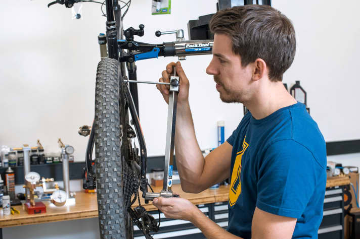 Richtwerkzeug verwenden: Bevor es ans Ausrichten geht, ist es wichtig, dass das Hinterrad gerade im Rahmen sitzt, keinen Seitenschlag hat und alle Schrauben fest sind. Danach wird mit der Richtlehre oben und unten an der Felge Maß genommen. Ist das Schaltauge gerade, sollte der Abstand der Lehre rundherum gleich sein. Ist er das nicht, kann man das Auge mit Hilfe der Lehre vorsichtig geradebiegen.