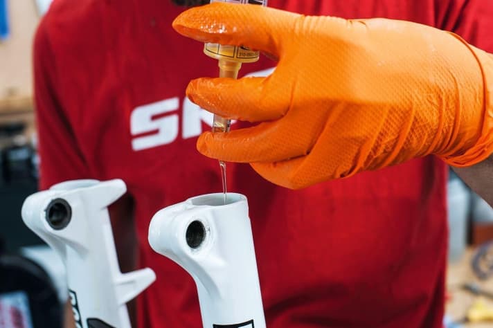   Handschuhe und Schutzbrille: Beim Gabel- und Dämpfer-Service, wie hier beim Ölwechsel, gilt: Aus Sicherheitsgründen sollten Sie immer Handschuhe und Schutzbrille tragen. Weil die Federelemente unter hohem Druck stehen, dürfen Sie außerdem nicht vergessen, vor dem Service die Luft abzulassen! Vorsicht: Die unsachgemäße Demontage kann sehr gefährlich werden!