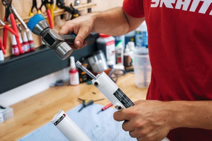   Ausschlagen der Tauchrohreinheit: Tauch - und Standrohreinheit sind noch immer fest zusammengepresst. Um die Verbindung zu lockern, müssen Sie von unten mit einem Gummihammer kräftig auf die Nuss am linken Holm klopfen, auf der rechten Seite auf den Inbus-Schlüssel. Erst dann kann man die Schrauben komplett lösen. 