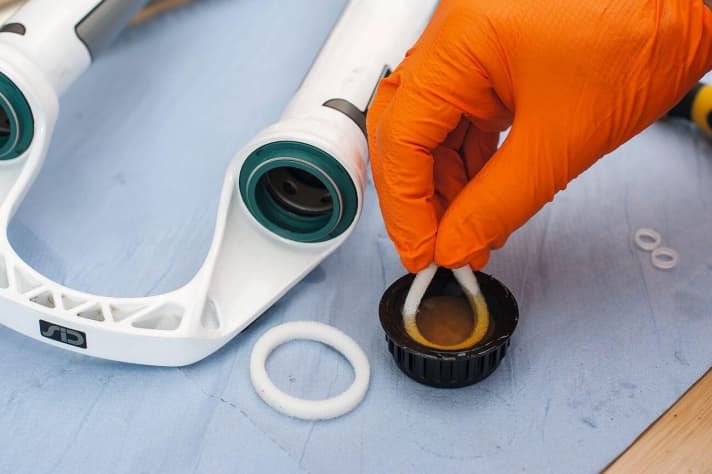    Schaumstoffringe baden: Die Schaumstoffringe, die unter den Staubdichtungen sitzen, sind für die Schmierung der Standrohre zuständig. Die neuen Ringe sollten ausreichend mit 15W-Gabelöl getränkt werden. Am besten badet man die Ringe für kurze Zeit in einem kleinen Schälchen oder dem Deckel der Ölflasche.