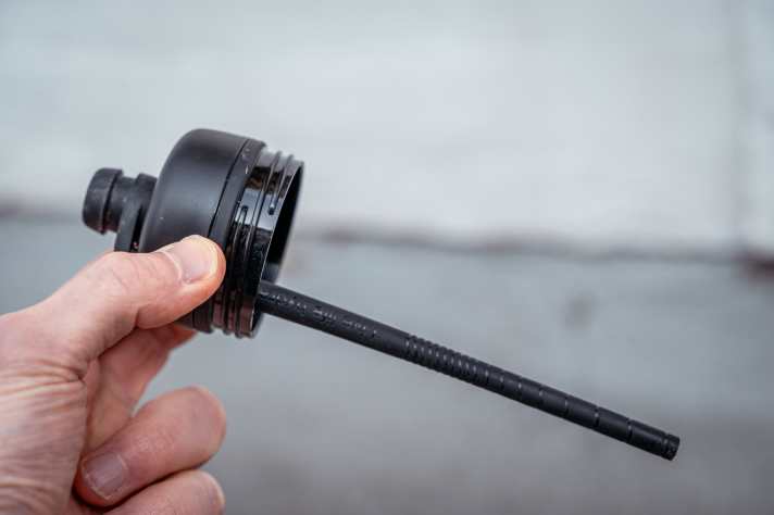 À l'intérieur se cache un petit tube spécial qui laisse entrer l'air dans la bouteille pour compenser. Si l'on ouvre l'embout, l'air s'engouffre dans le bivouac et l'eau jaillit - sans aucun effort.