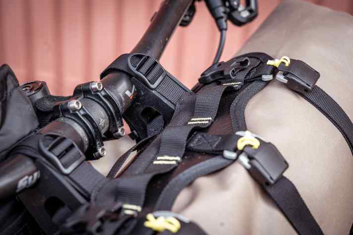 Per Abstandshalter und Zurrgurte wird das Harness am Lenker fixiert