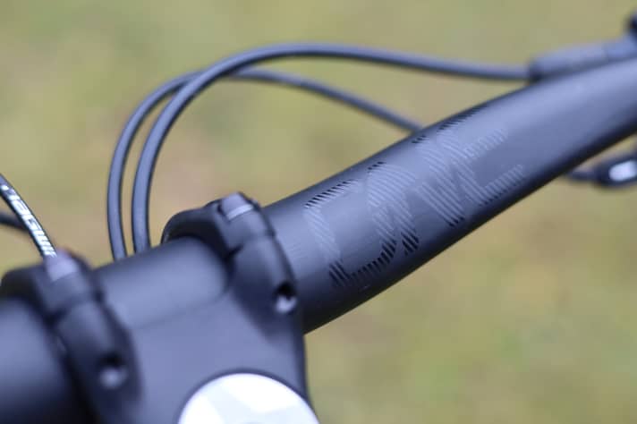 The discreet black look of the OneUp carbon handlebars can be customised with stickers.