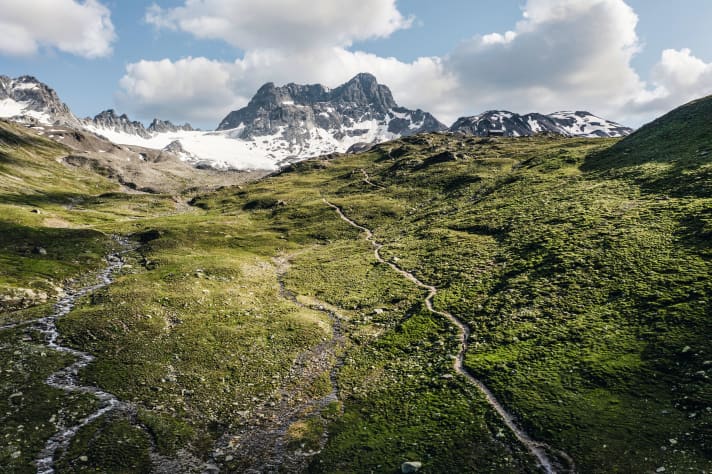 Selbst der Schmelzwasser-Bach hat es in dieser Bergflanke nicht so eilig, wie der Trail. Allerdings bummelt das Wasser bergab, während Biker sich hier zur Keschhütte erst noch hochkämpfen müssen.