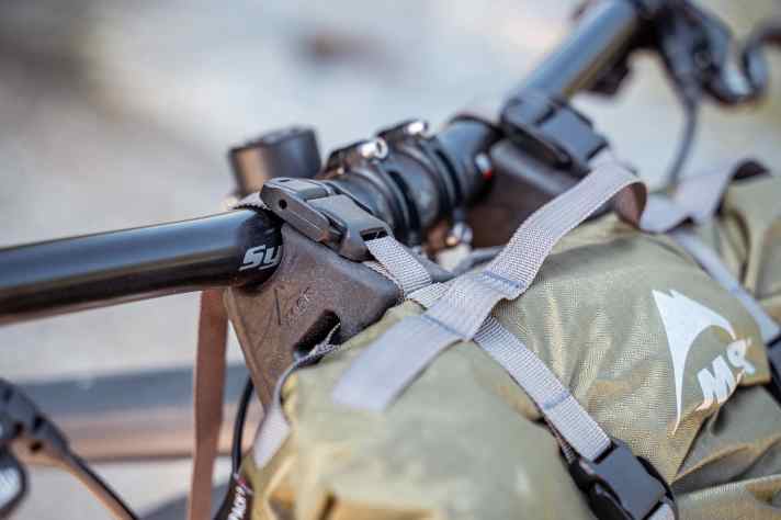 The pannier is strapped to the handlebars using spacers, leaving space for cable routing